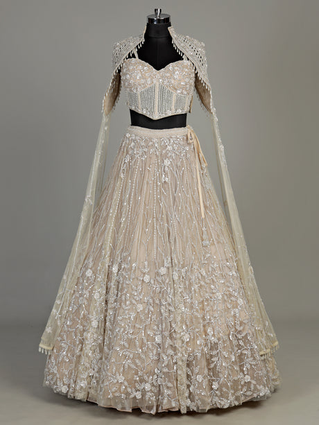 Beige net designer lehenga choli with heavy embellished cape shrug