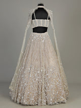 Beige net designer lehenga choli with heavy embellished cape shrug