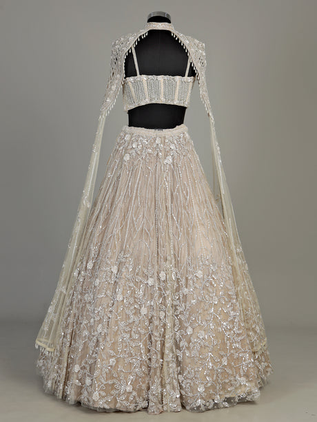 Beige net designer lehenga choli with heavy embellished cape shrug