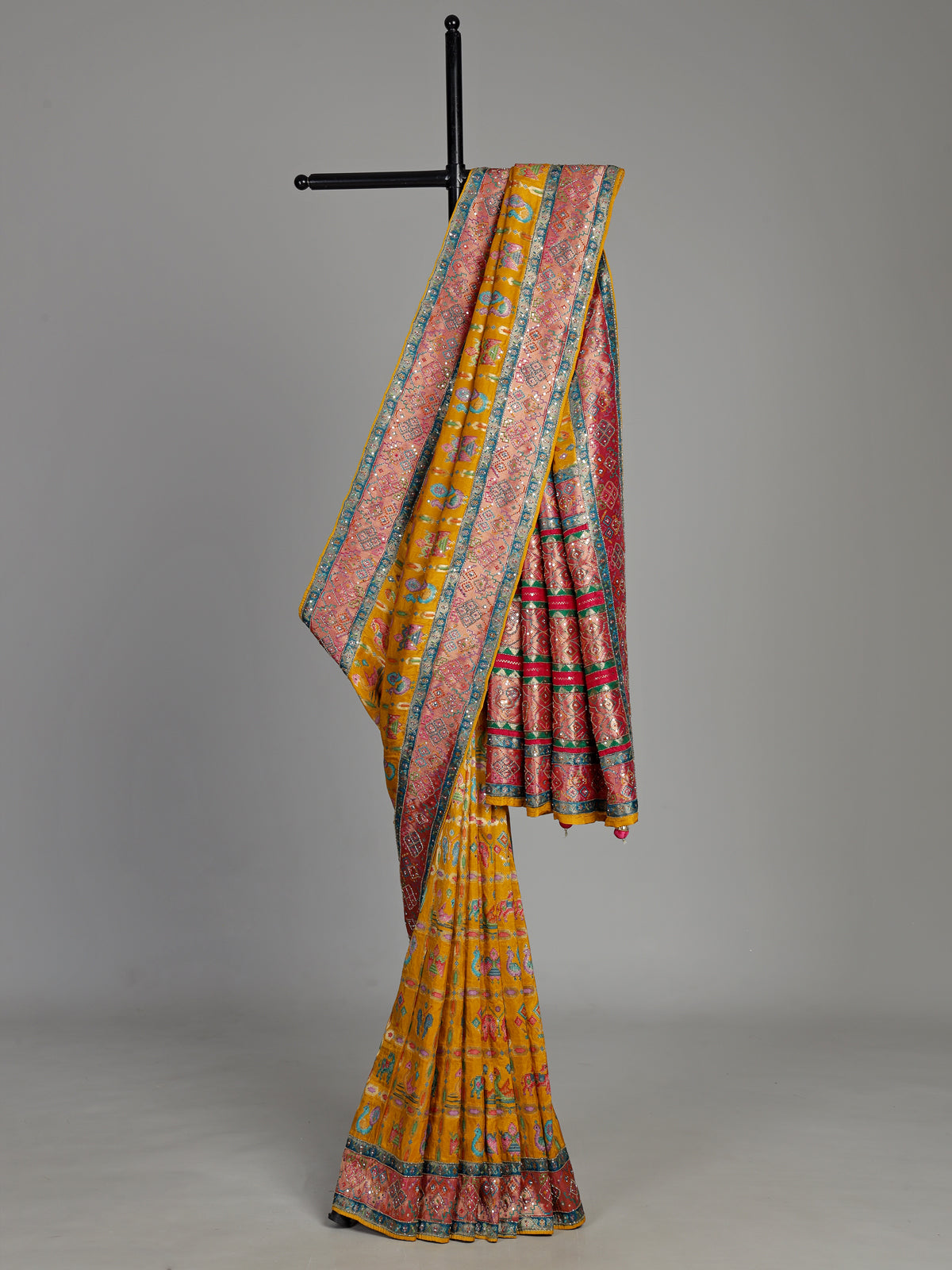 Mustard yellow modal satin saree with colourful motifs and tassel detailing
