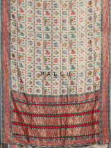 Cream modal satin saree with colourful motifs and intricate zari embellishments
