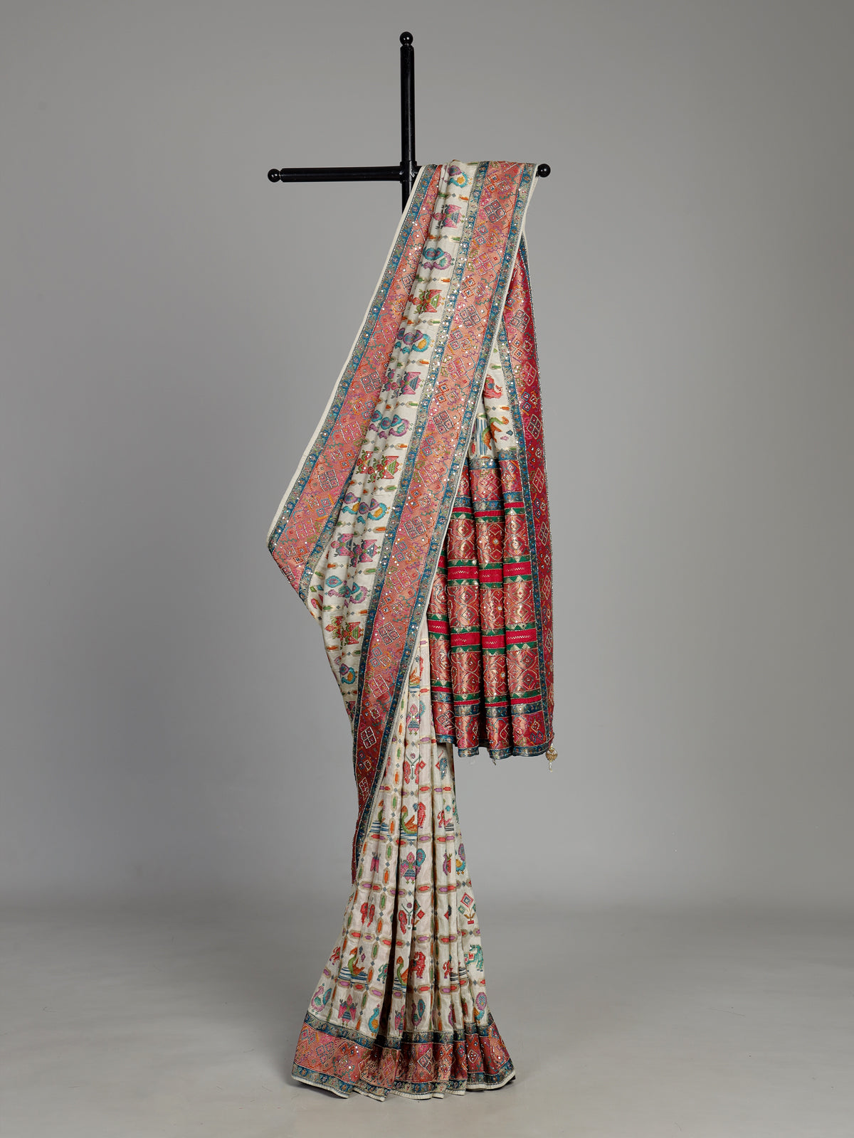 Cream modal satin saree with colourful motifs and intricate zari embellishments