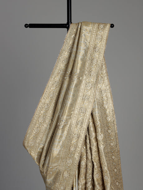 Pastel cream tissue silk saree with intricate festive embellishments and zari