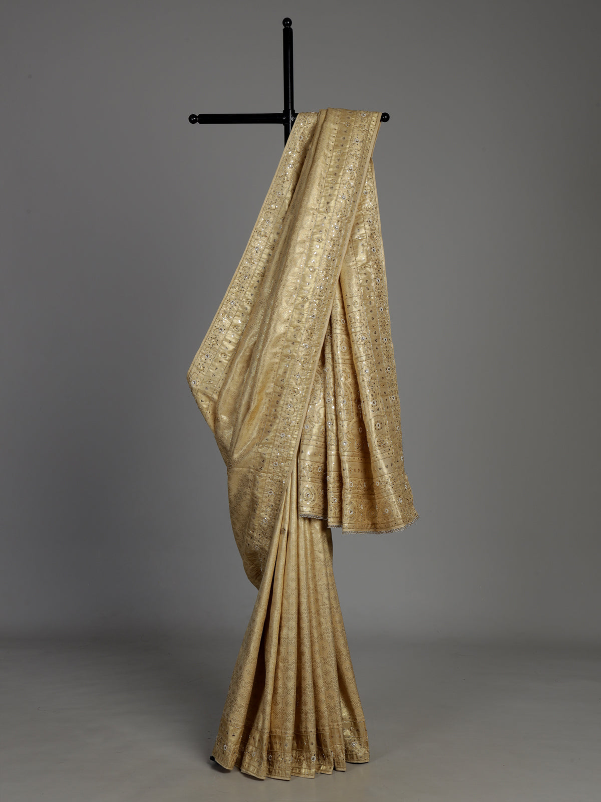 Cream tissue silk saree with mirror accents and intricate festive embroidery