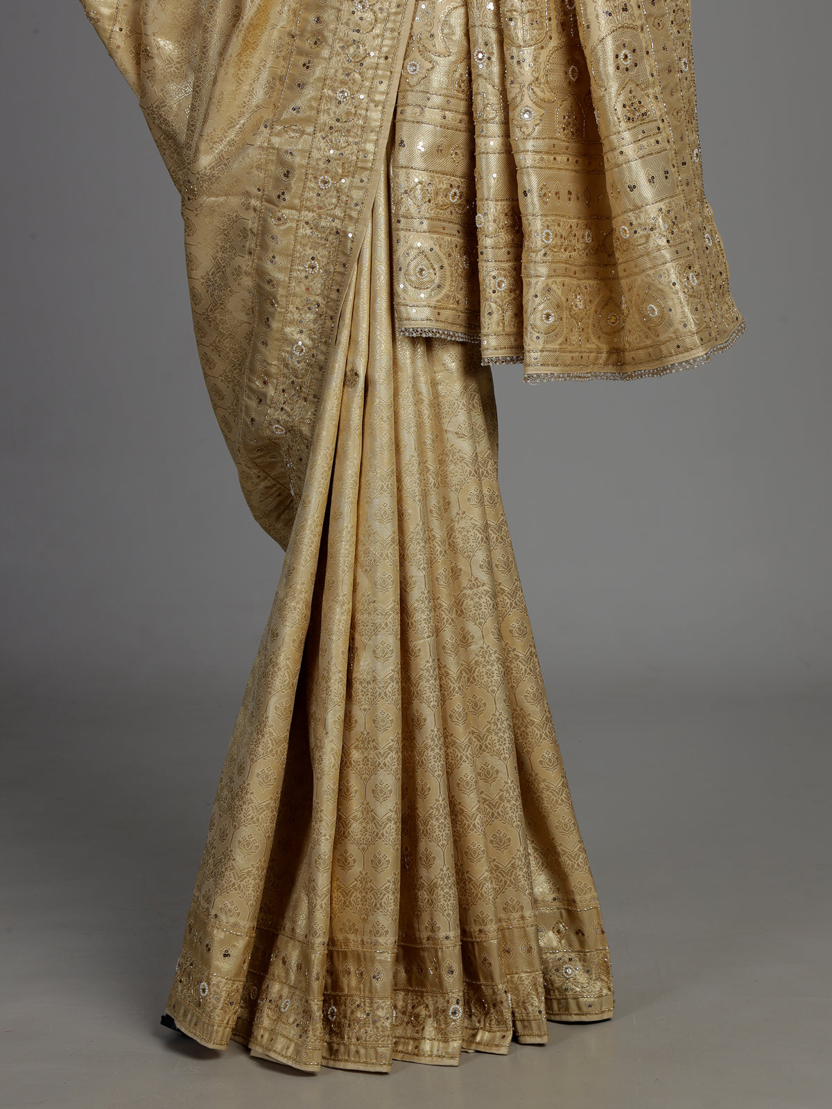 Cream tissue silk saree with mirror accents and intricate festive embroidery