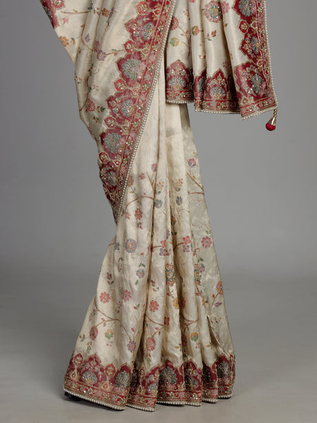 Cream pashmina saree with floral motifs and contrasting embellished border