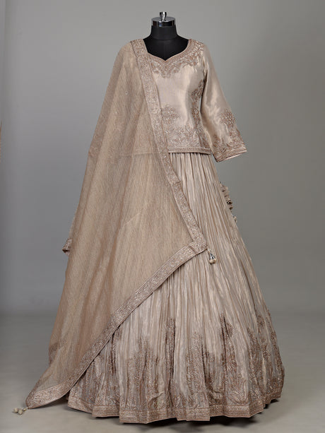 Pastel beige tissue silk lehenga choli with intricate zardosi detailing
