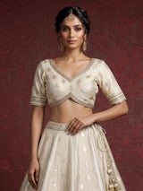 Cream banarasi silk lehenga choli with intricate zardosi embellishments