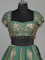 Green silk lehenga choli with intricate zardosi and tassel detailing