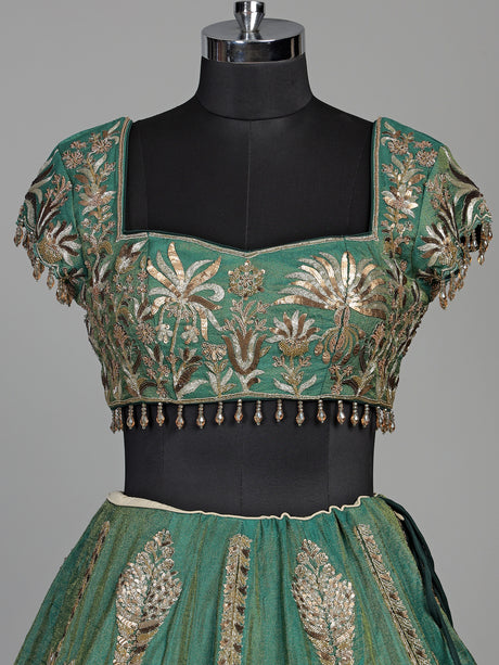 Green silk lehenga choli with intricate zardosi and tassel detailing