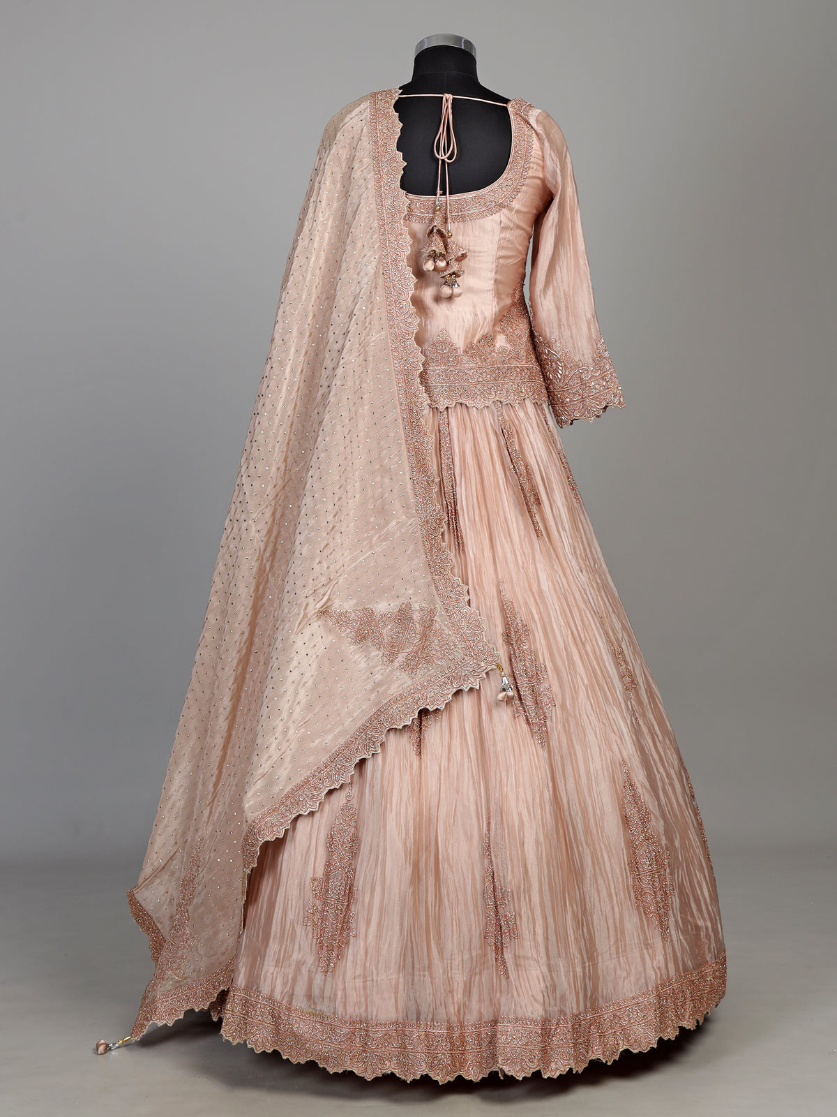 Pastel peach tissue silk lehenga choli with intricate cutdana embellishments
