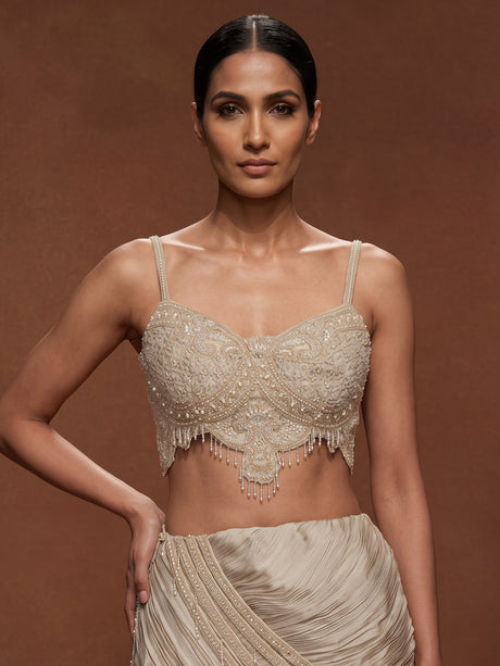 Cream chiffon georgette lehenga choli with pearl and tassel embellishments