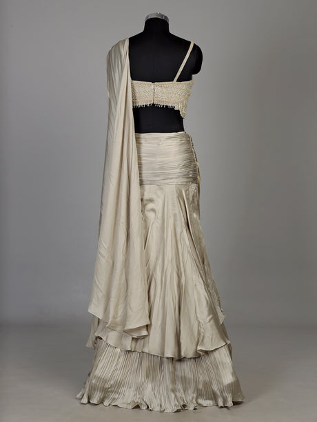 Cream chiffon georgette lehenga choli with pearl and tassel embellishments