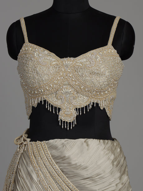 Cream chiffon georgette lehenga choli with pearl and tassel embellishments