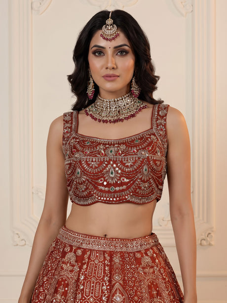 Rust orange silk lehenga choli with mirror and zardosi work