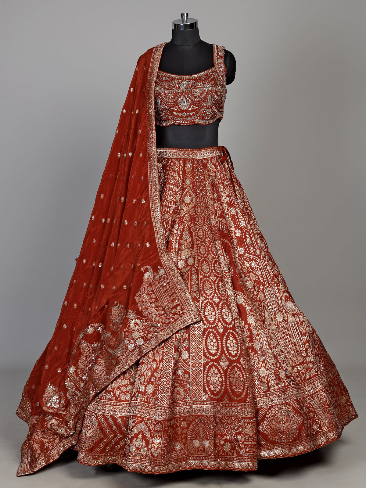 Rust orange silk lehenga choli with mirror and zardosi work