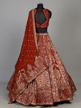 Rust orange silk lehenga choli with mirror and zardosi work