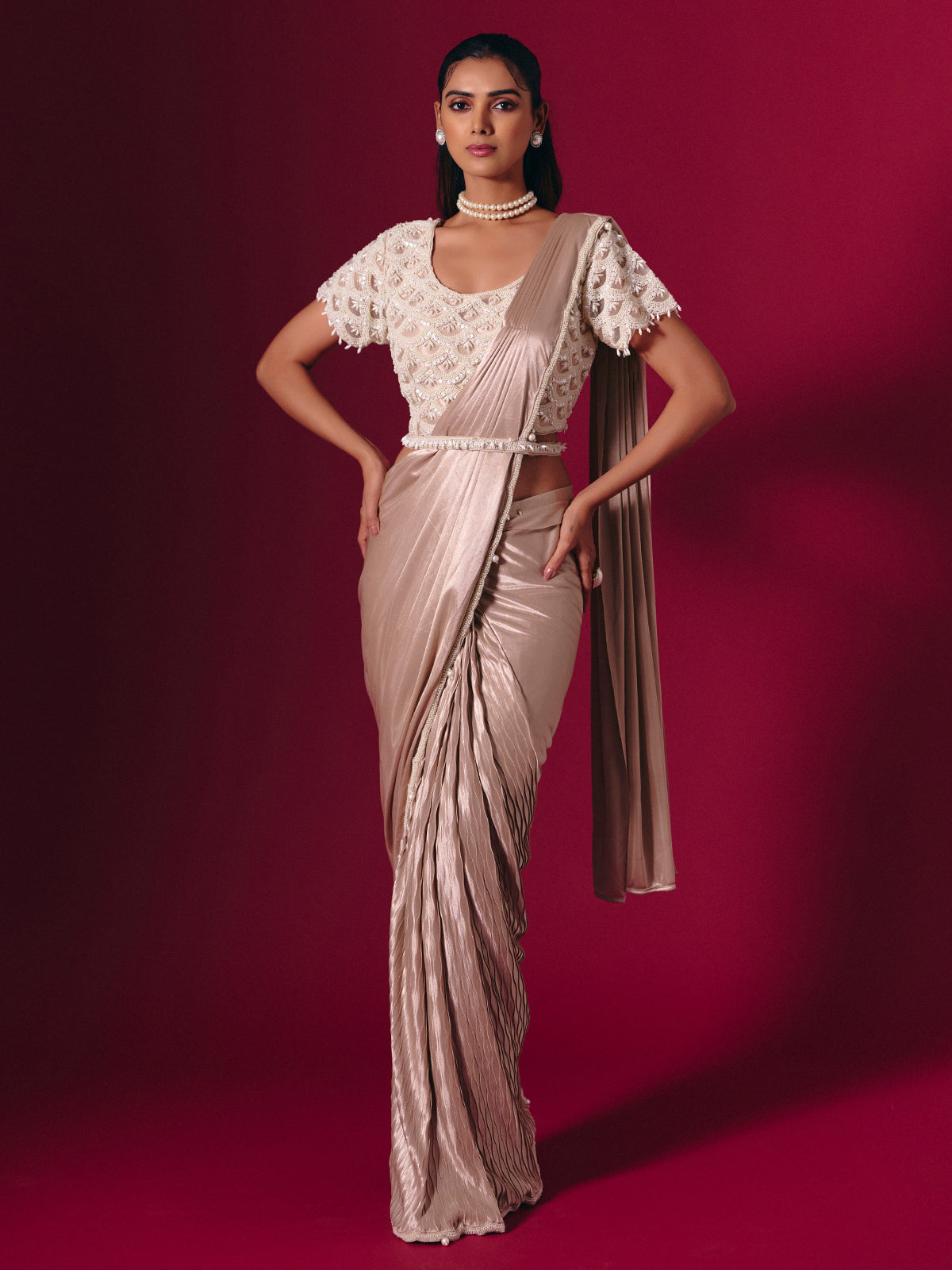 Pastel peach shimmer saree with elegant pearl embellishments