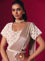 Pastel peach shimmer saree with elegant pearl embellishments