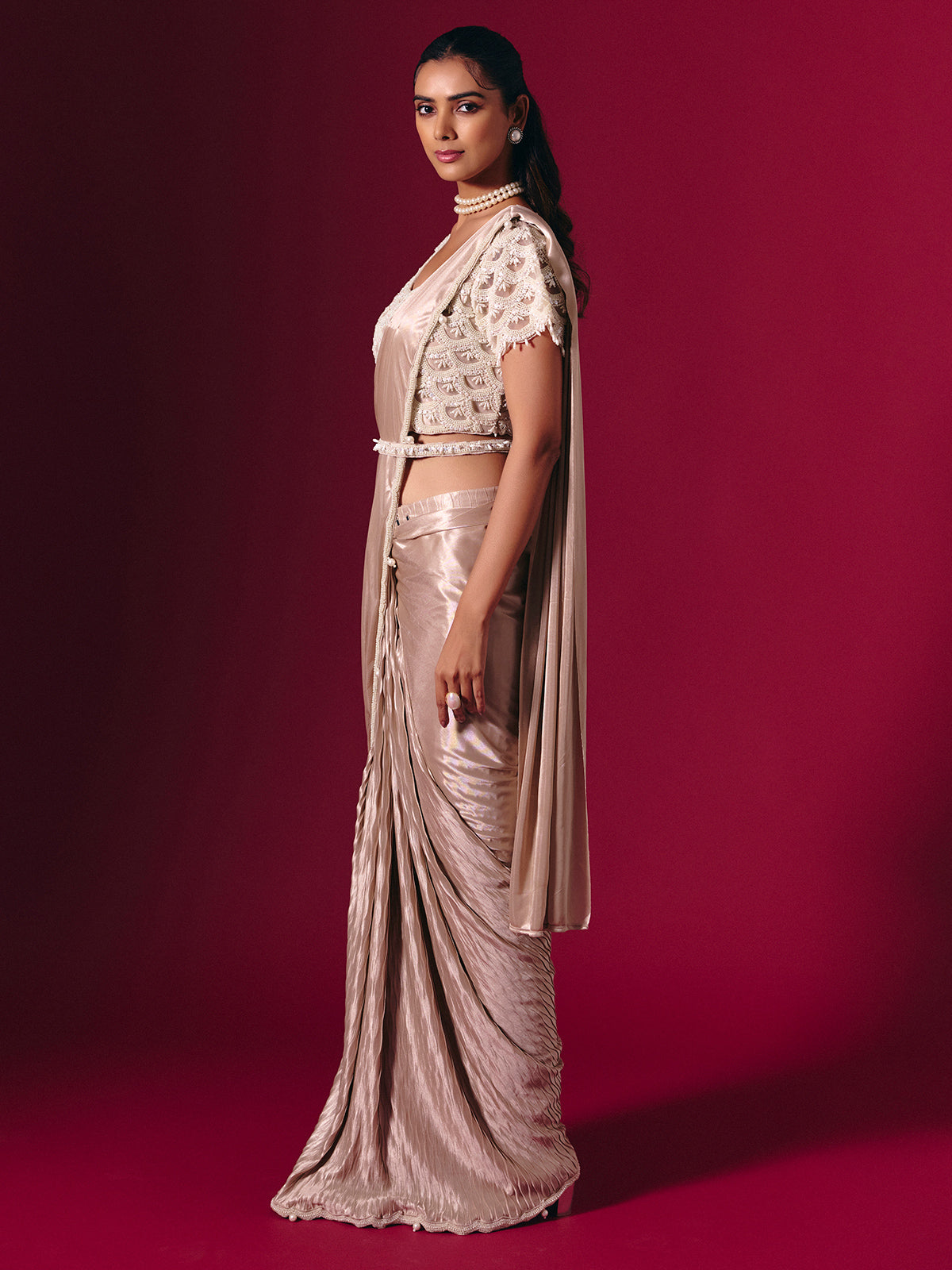 Pastel peach shimmer saree with elegant pearl embellishments
